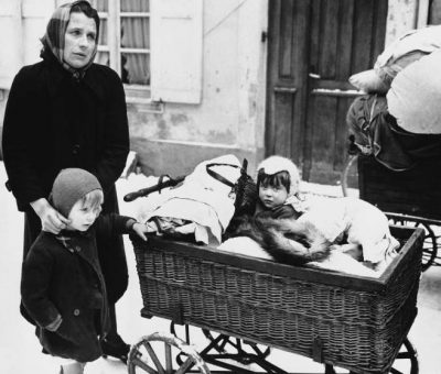Frenchwoman with two children and belongings loaded on a baby carriage seen in Haguenau, France on Feb. 20, 1945, before they started on their long trek to a safe rear area. They are some of the refugees leaving the town because of the planned withdrawal of the 7th U.S. Army. Many civilians prefer to leave their homes and seek safety in a rear area, rather than suffer another German occupation or risk being conscripted into the German Vollksturn. (AP Photo)