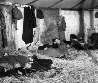 25th October 1945: German refugees fleeing from the Russian zone in the first few weeks after the end of World War II in Europe. They are sleeping on straw in a makeshift transit camp at Uelzen in the British zone of Germany. (Photo by Keystone/Getty Images)